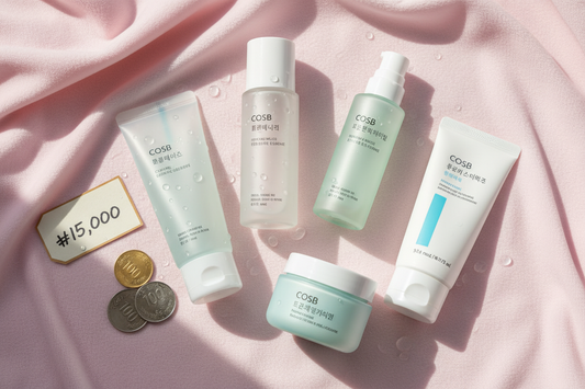 Affordable K-beauty skincare routine flat-lay featuring a gel cleanser, toner, snail mucin essence, moisturizer, and SPF sunscreen on a pastel pink background — complete budget-friendly Korean skincare routine under $30
